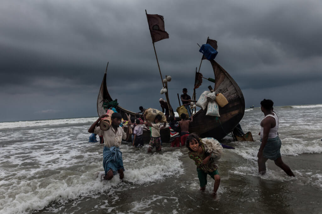 Noor Haba, 11, carries her family's belongings to Shamlapur Beach in Bangladesh after the boat she traveled on from Maungdaw Township, Myanmar arrived safely at 8:43 a.m. Patrick Brown © Panos/UNICEF 2018
