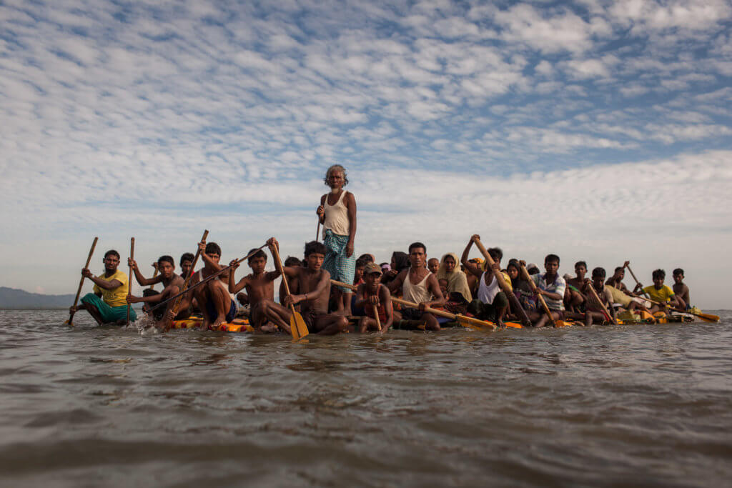 Rohingya refugees cross the Naf River on a makeshift raft made of bamboo and empty palm-oil cans—a five to seven-hour-long journey. Patrick Brown ©Panos/UNICEF 2018